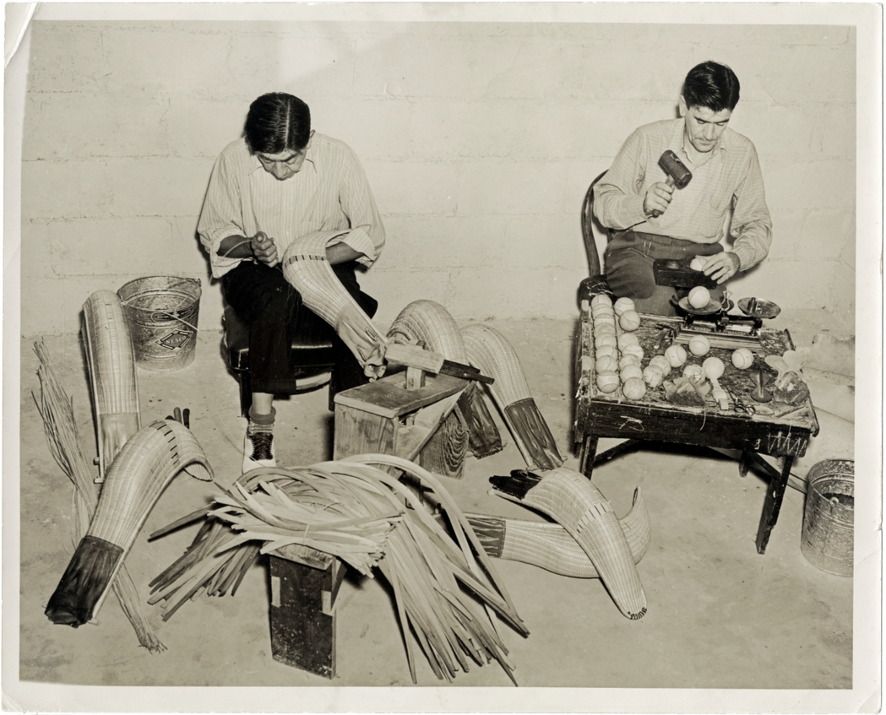 Historic archival photograph of Basque craftsmen hand-weaving cestas and finishing pelotas.